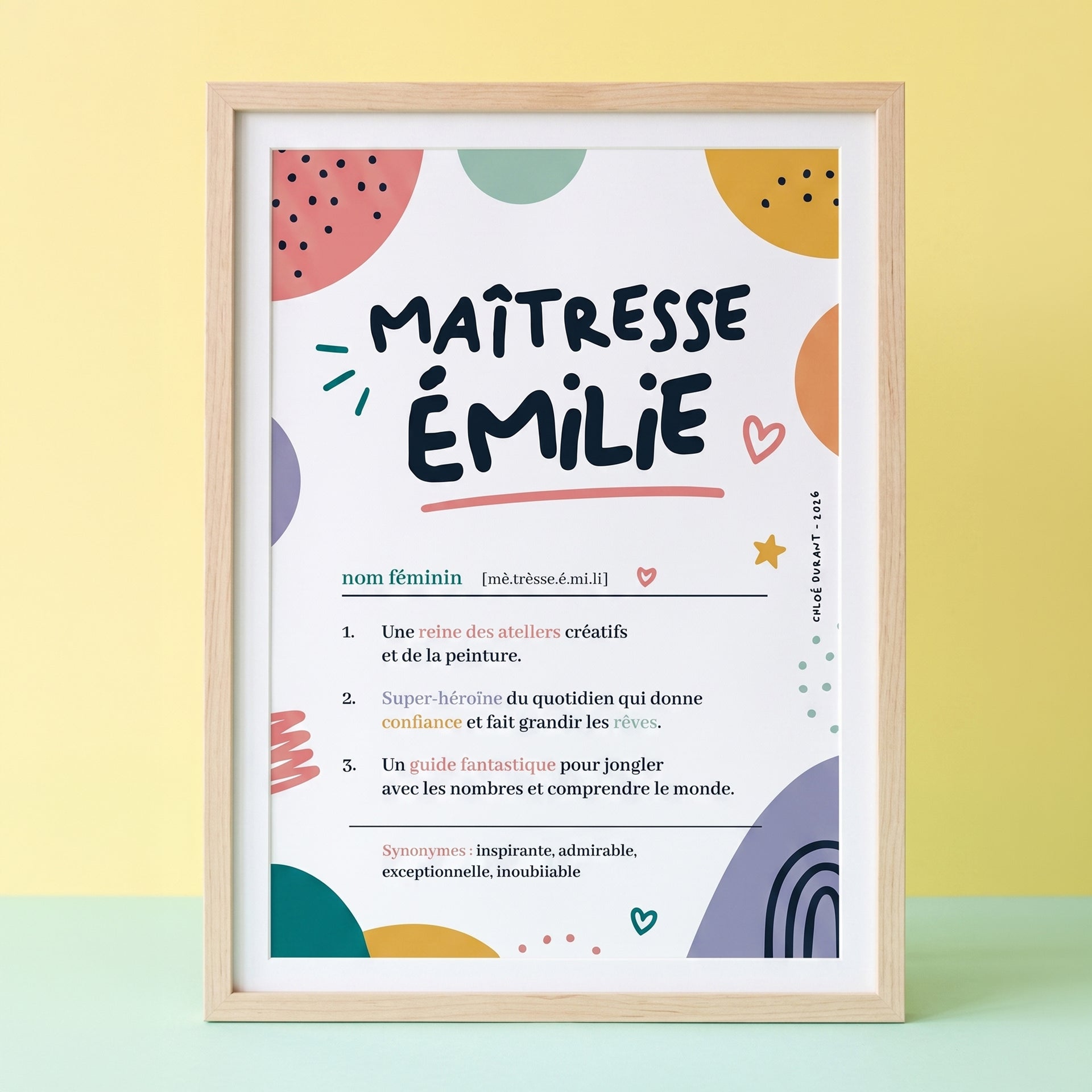 Affiche personnalisée Maîtresse Émilie style définition de dictionnaire, présentée dans un cadre en bois sur un fond pastel jaune et vert.