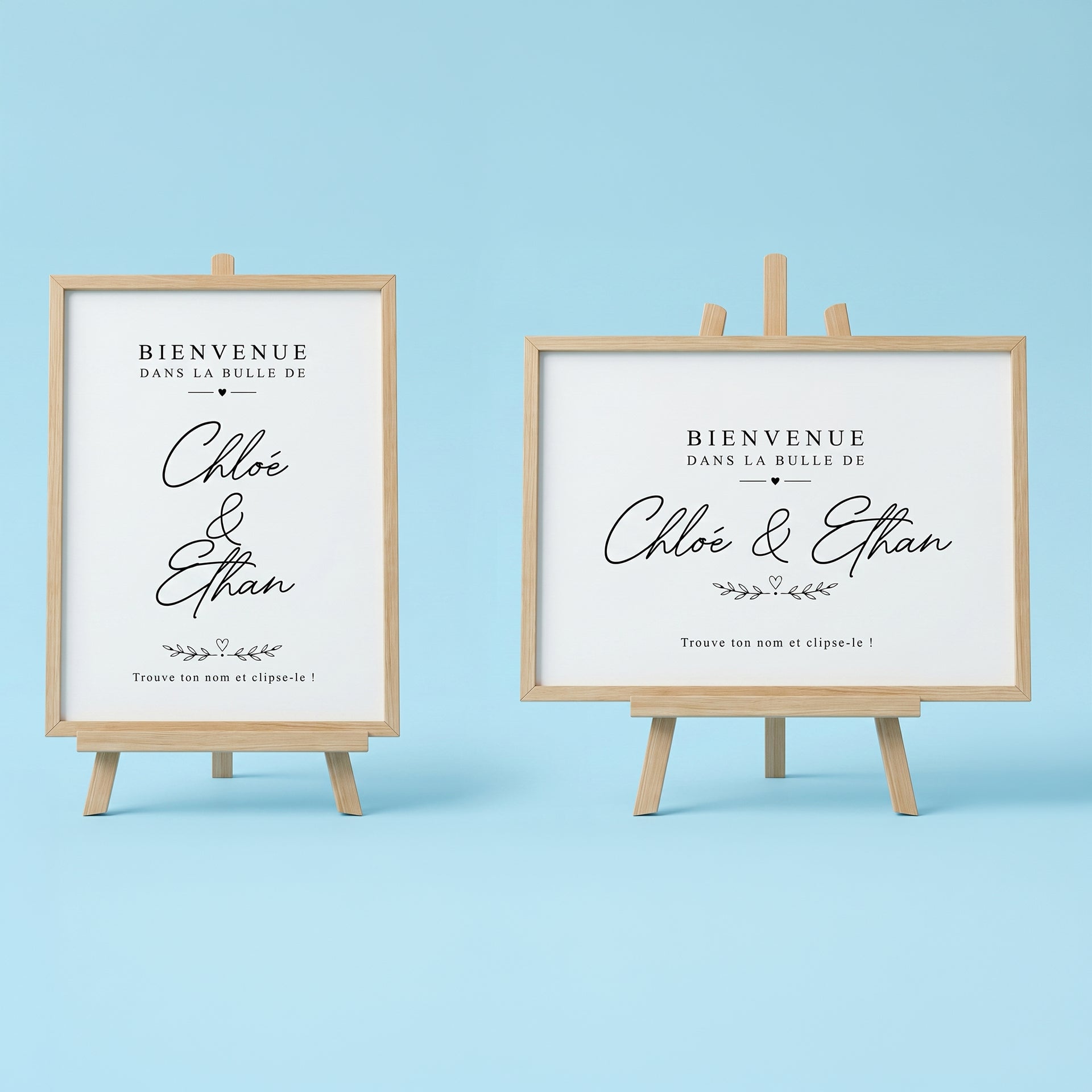 Deux affiches numériques de bienvenue pour mariage sur mini-chevalets en bois clair, formats vertical et horizontal. Texte noir élégant 'Bienvenue dans la bulle de Chloé & Ethan' en écriture script, avec motifs de cœurs et instruction 'Trouve ton nom et clipse-le !' pour marque-verres, sur fond bleu pastel.