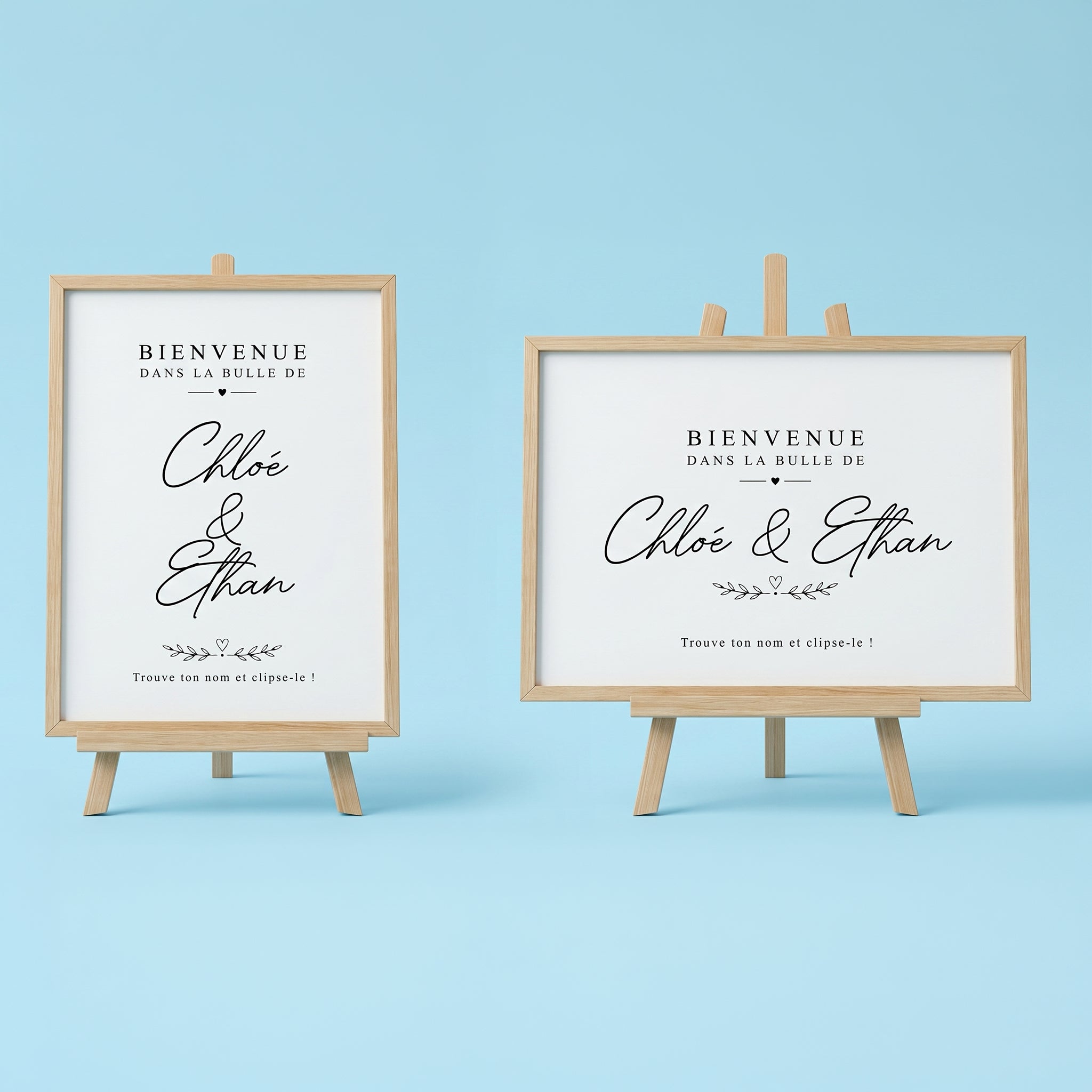 Deux affiches numériques de bienvenue pour mariage sur mini-chevalets en bois clair, formats vertical et horizontal. Texte noir élégant 'Bienvenue dans la bulle de Chloé & Ethan' en écriture script, avec motifs de cœurs et instruction 'Trouve ton nom et clipse-le !' pour marque-verres, sur fond bleu pastel.