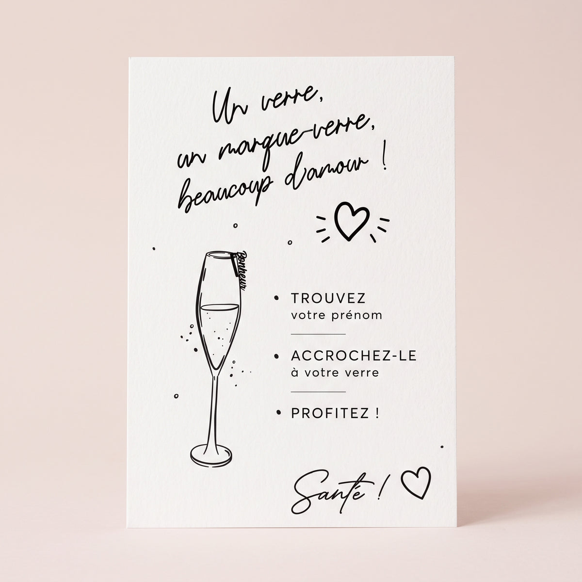 Packshot carré de l’affiche « Un verre, un marque-verre, beaucoup d'amour » imprimée sur papier blanc texturé, posée au centre sur un fond uni rose poudré pastel et lumineux. Le visuel comprend une flûte de champagne illustrée au trait noir ornée d’un marque-verre, des cœurs et les consignes pour les invités terminées par la mention « Santé ! ».
