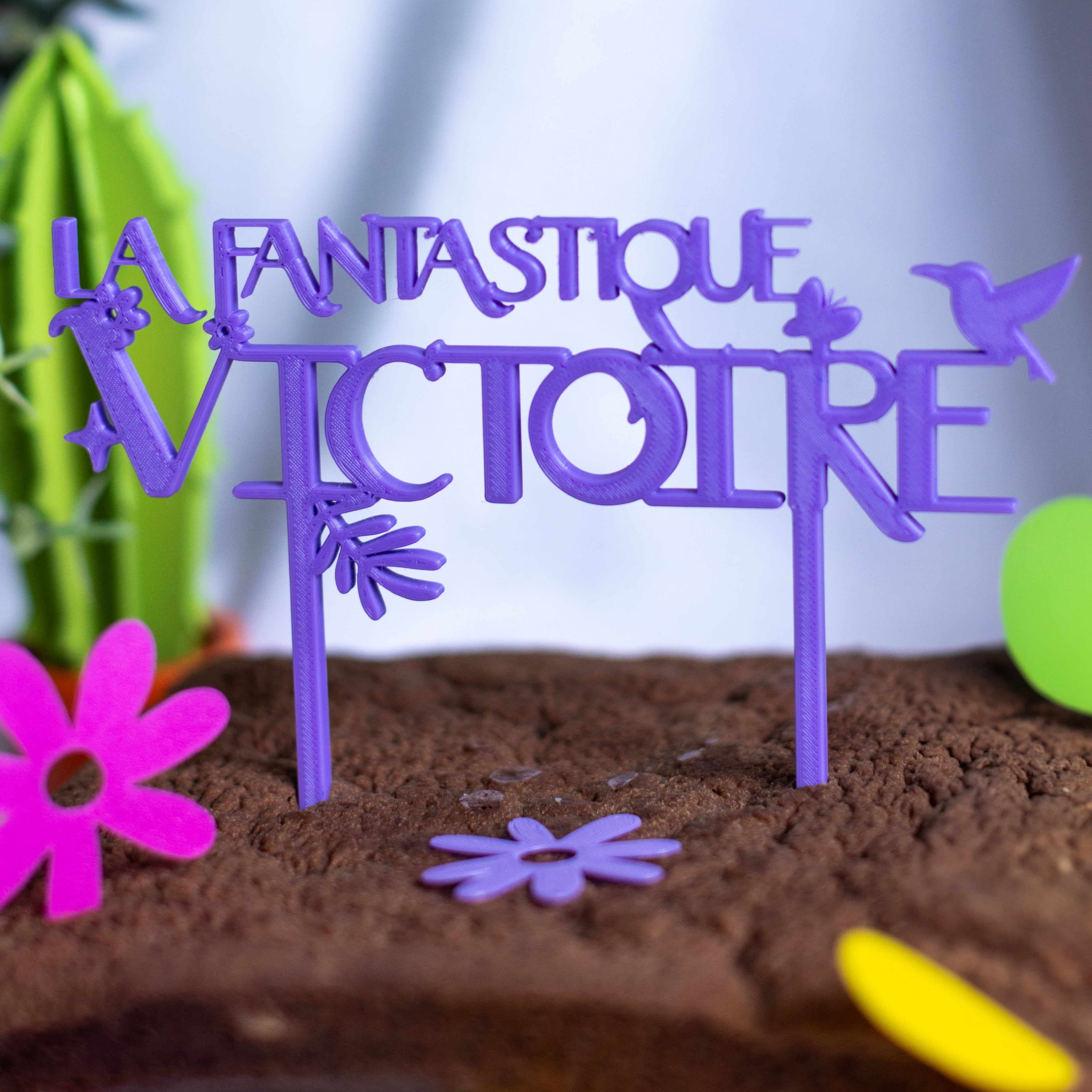 Cake-topper violet “La Fantastique Victoire” inspiré d’Encanto, décoré de fleurs et oiseaux, planté sur un gâteau au chocolat