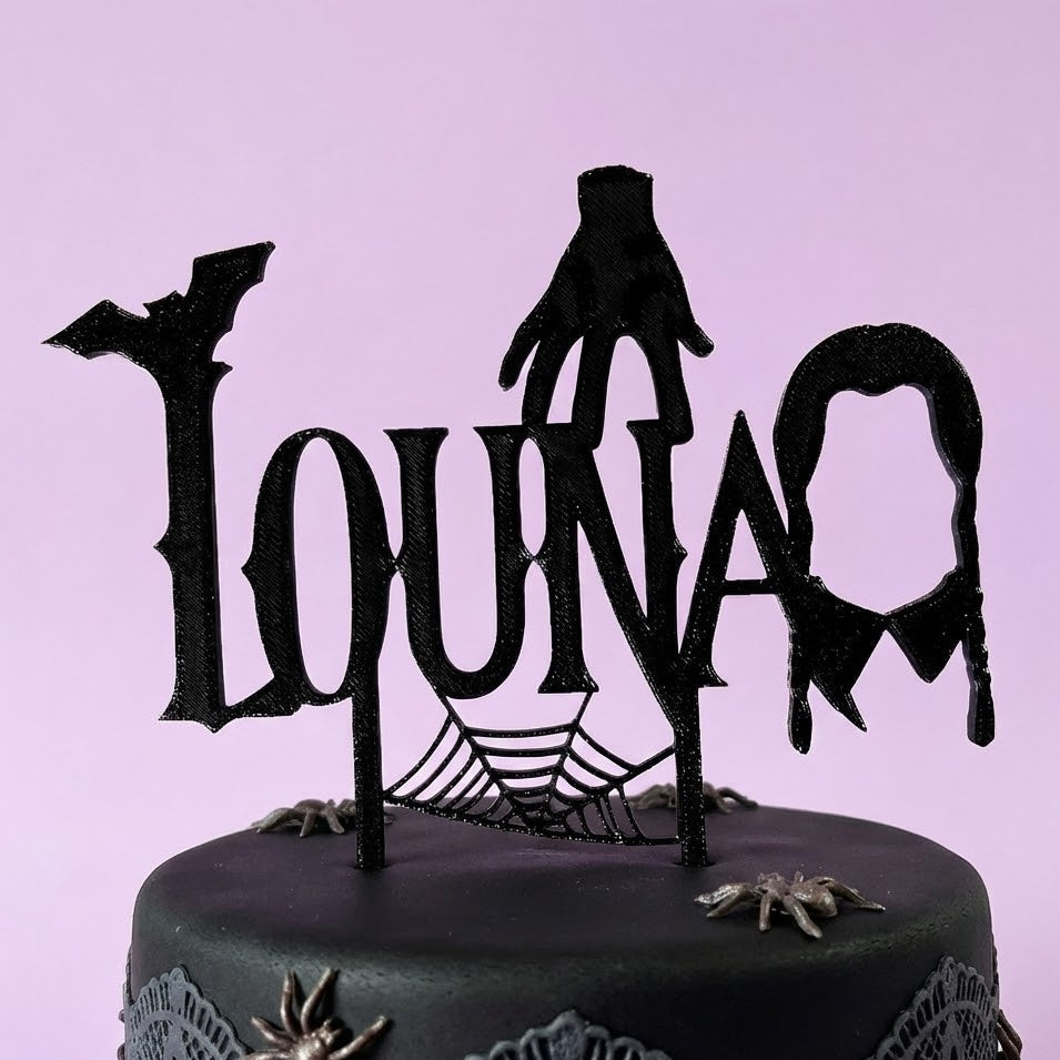 Cake topper personnalisé style Mercredi Addams avec prénom Luna, main et chauve-souris, toile d’araignée noire sur gâteau anniversaire thème gothique.