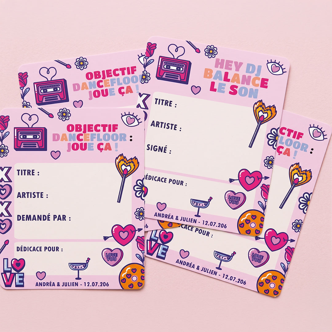 "Packshot de quatre coupons 'Carte DJ - Jukebox' personnalisés, disposés en éventail sur un fond uni rose pastel lumineux. Les cartes au style rétro affichent des illustrations festives de cassettes et de cœurs, avec des champs à remplir pour le titre, l'artiste et la dédicace."
