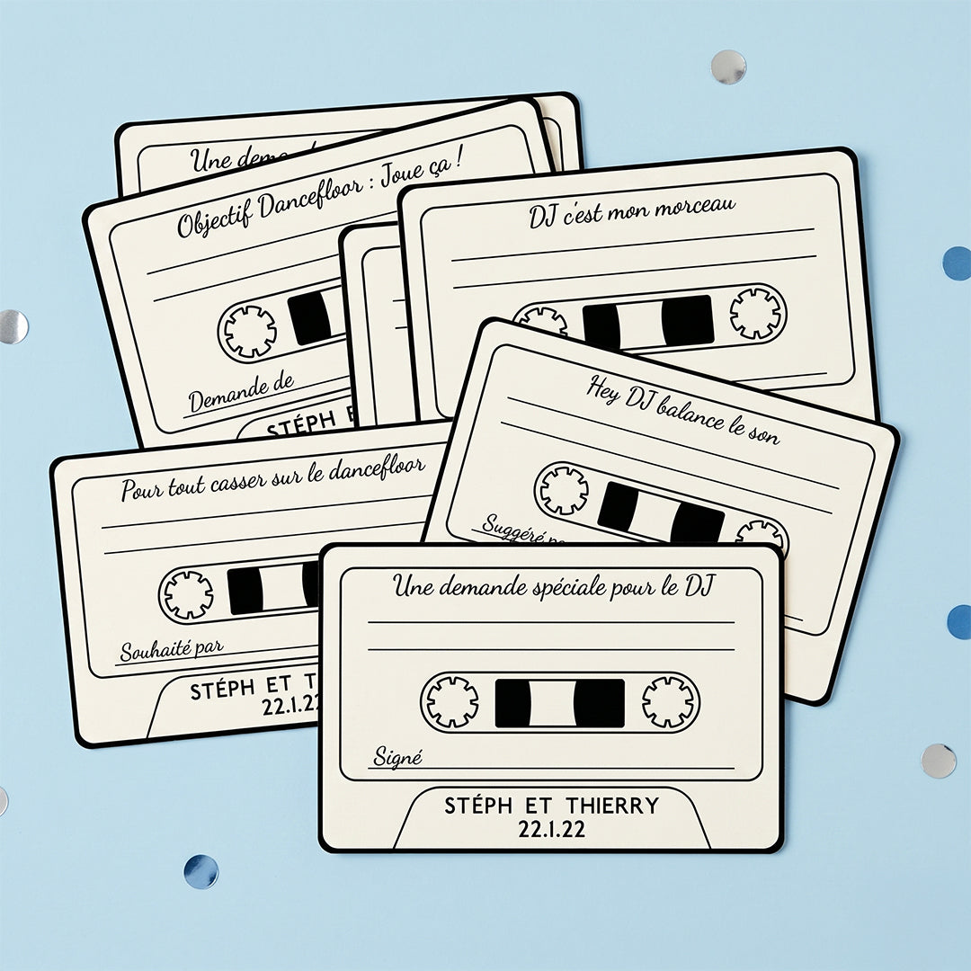 Lot de cartes de suggestions musicales et dédicaces personnalisées pour mariage, design cassette rétro, présentées en packshot sur un fond uni bleu pastel lumineux.