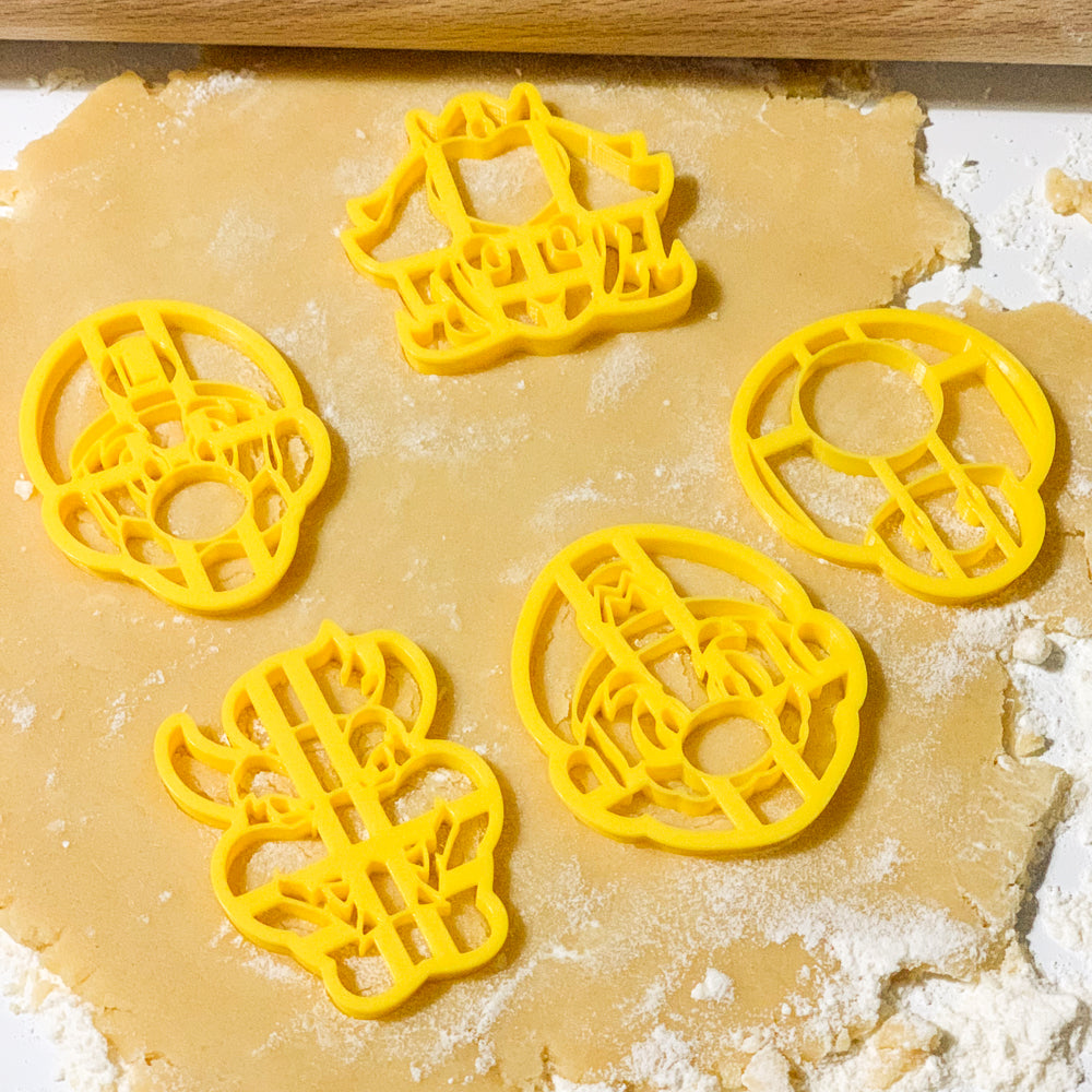Biscuits formes Mario Luigi Peach Toad et Bowser realises avec des emporte-pieces jaunes sur une pate a biscuits