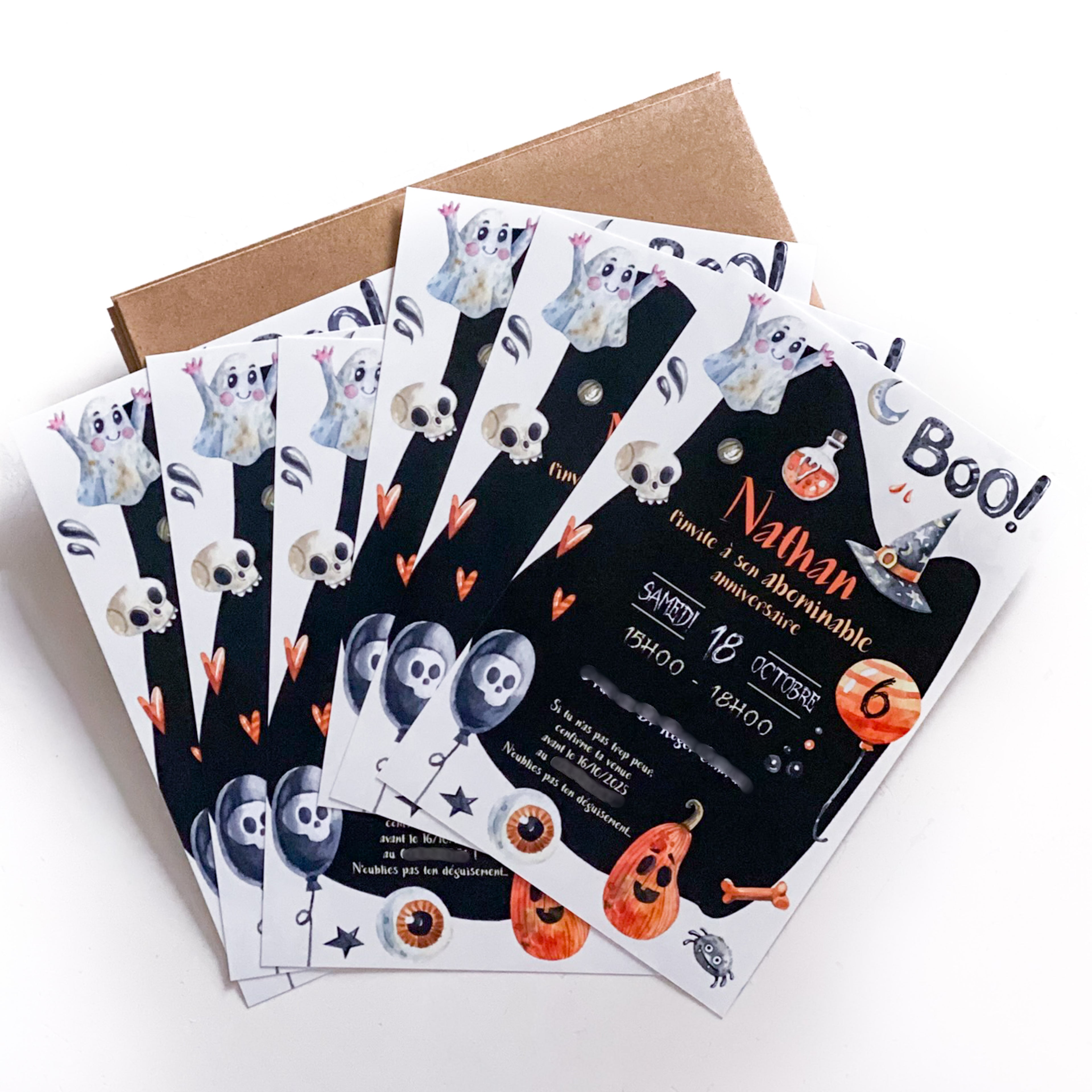 Six invitations d’anniversaire Halloween en éventail sur une enveloppe kraft. Fond noir en silhouette de fantôme avec le mot “Boo !”. Illustrations aquarellées : petits fantômes, fioles, chapeau de sorcière, cœurs orange, crânes, ballons tête de mort, citrouilles, os et grands yeux. Prénom “Nathan” en orange, date “Samedi 18 octobre”, horaire “15h00–18h00”, ballon orange marqué “6”.