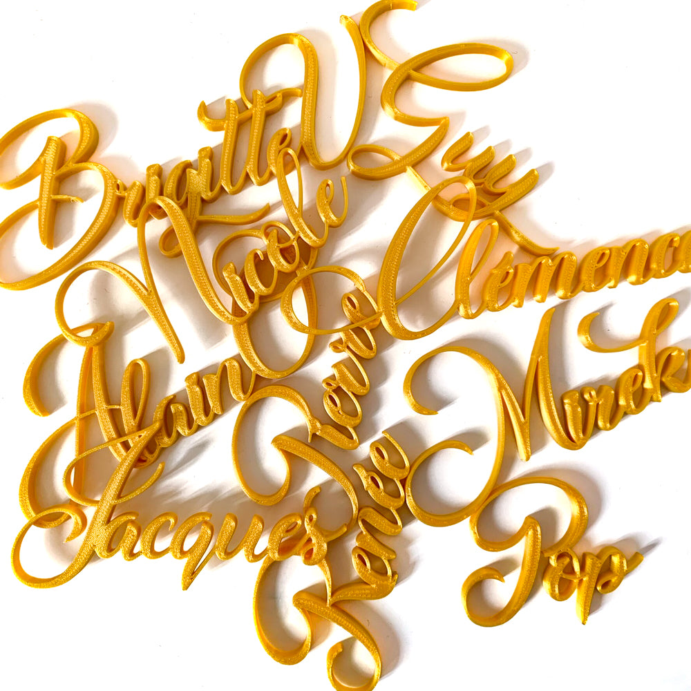 Ensemble de marque-places calligraphie dorés personnalisés avec différents prénoms, aux courbes élégantes et raffinées, présentés sur fond blanc.