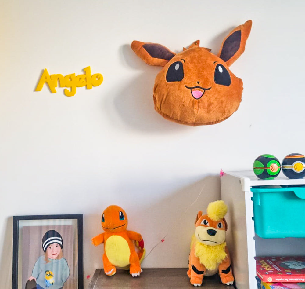 Prenom Angelo en lettres 3D jaunes fixe au mur dans une chambre d enfant, decoration personnalisee en PLA dans un univers inspire de Pokemon.