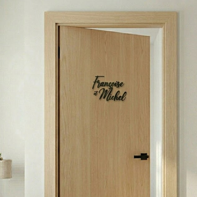 Prénoms « Françoise et Michel » en décoration murale en impression 3D, posés sur une porte en bois clair.