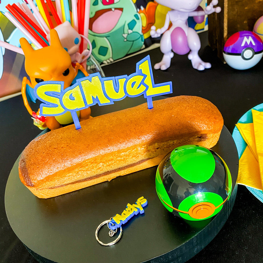 Cake topper Pokémon personnalisé avec le prénom Samuel posé sur un gâteau d’anniversaire, décoration sur le thème Pokémon avec univers manga et figurines.