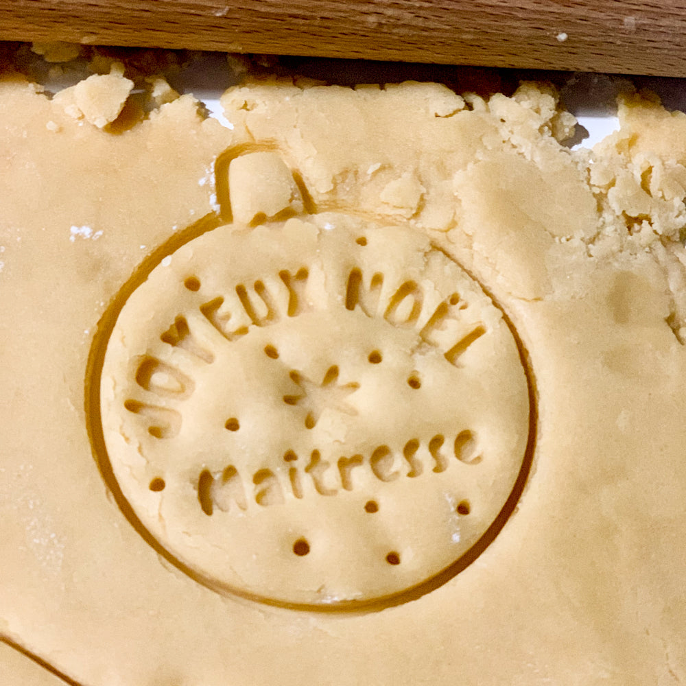 Empreinte biscuit Joyeux Noël Maîtresse réalisée avec un emporte-pièce boule en pâte sablée.