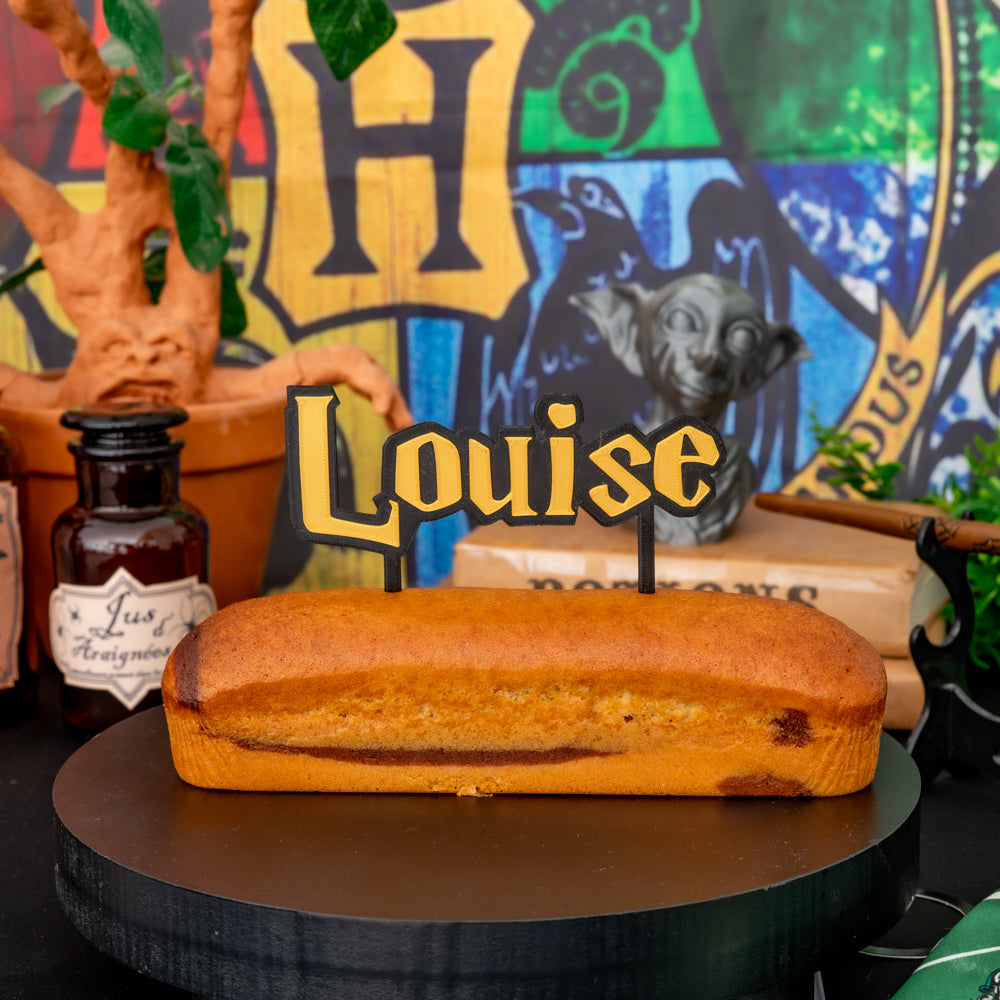 Cake topper prénom Louise style Harry Potter posé sur gâteau d’anniversaire thème sorcier, décoration personnalisée en impression 3D.