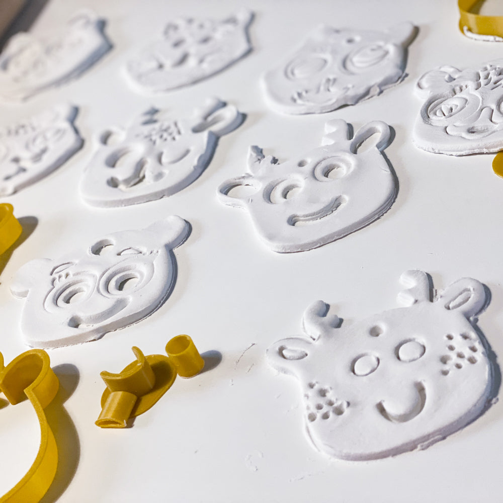 Empreintes de têtes d’animaux de Noel realisees avec des emporte-pieces jaunes, activite creative enfants en pate autodurcissante.