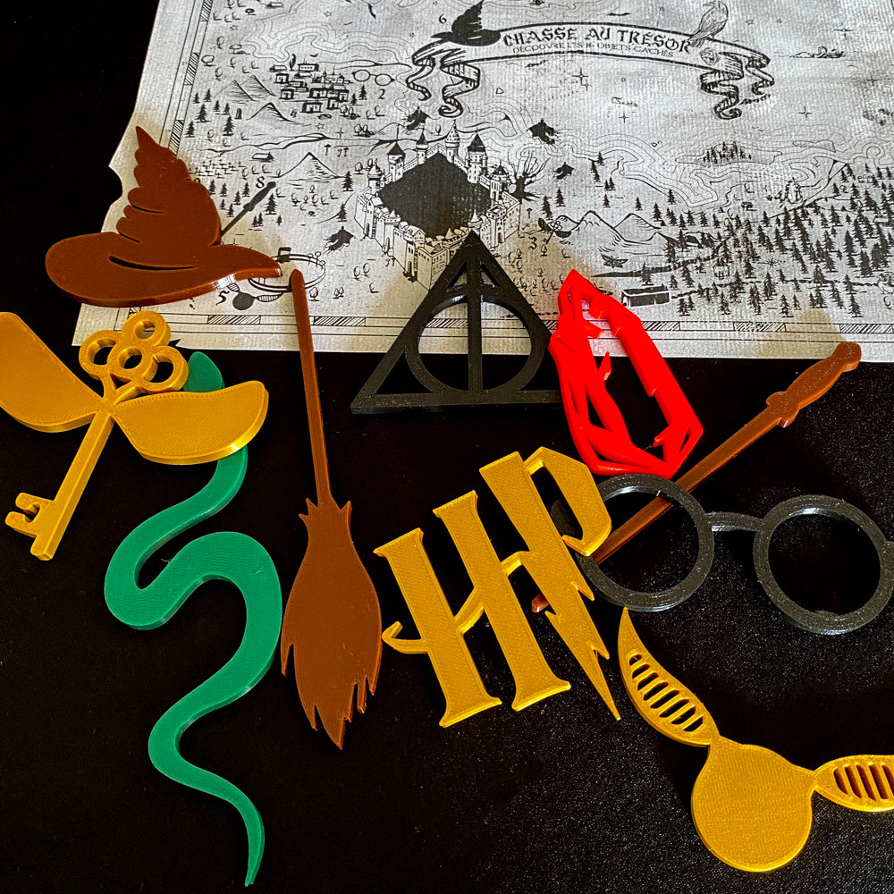 Jeu de chasse au trésor inspiré de l’univers des sorciers, avec carte magique en format A3 à imprimer et 10 objets imprimés en 3D colorés à retrouver. Idéal pour anniversaire enfant ou activité immersive sur le thème Harry Potter. Carte visible en noir et blanc, objets en PLA posés sur fond noir.