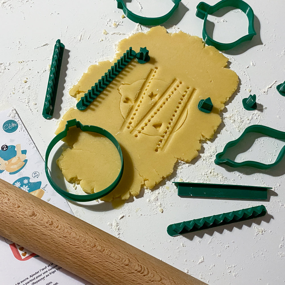 Kit créatif emporte-pièces boules de Noël avec tampons décoratifs sur pâte à biscuits.