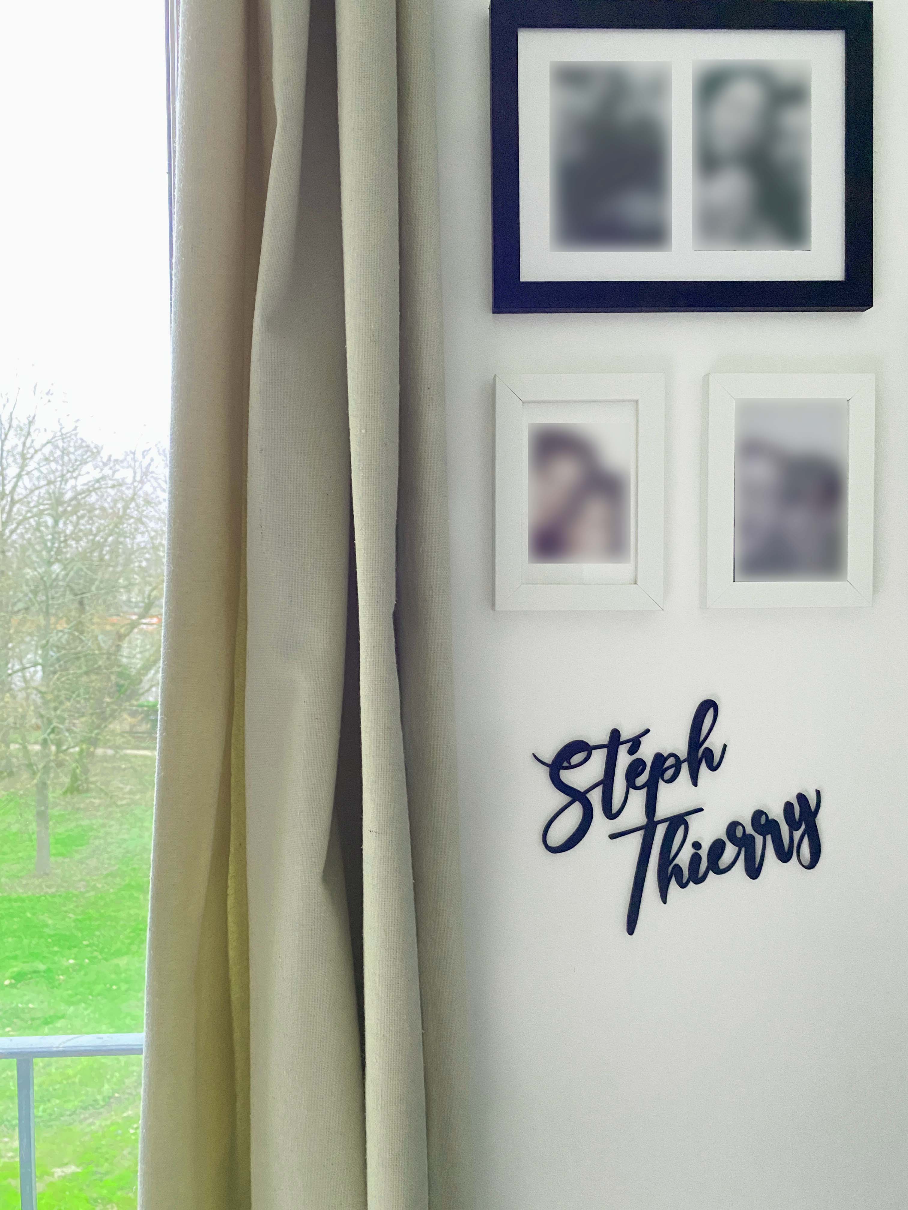 Décoration murale prénoms « Steph » et « Thierry » en impression 3D, accrochée au mur près de cadres photo et d’une fenêtre.
