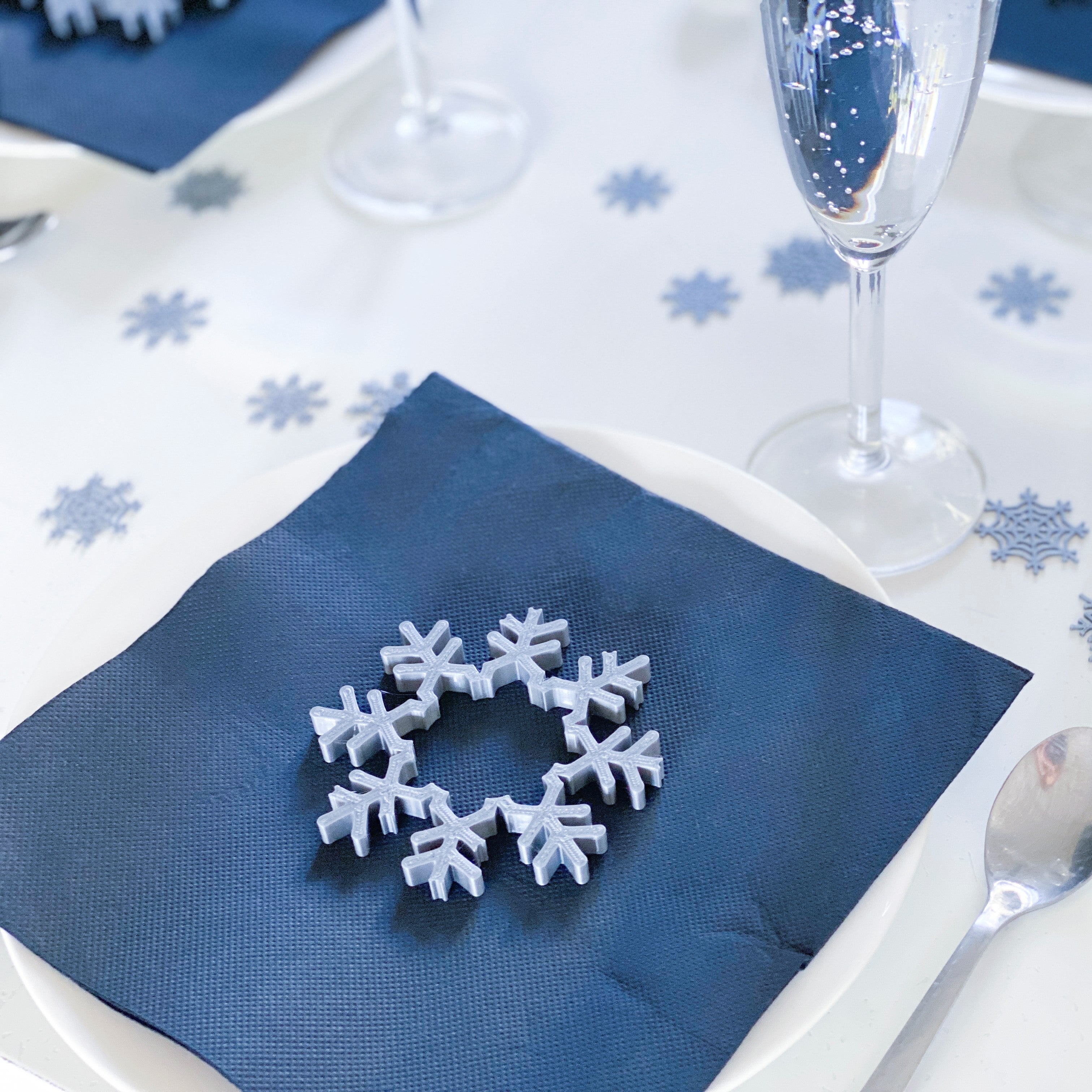 On aperçoit également les gros confettis flocons assortis, parfaits pour compléter la décoration de table et créer une ambiance hivernale harmonieuse.