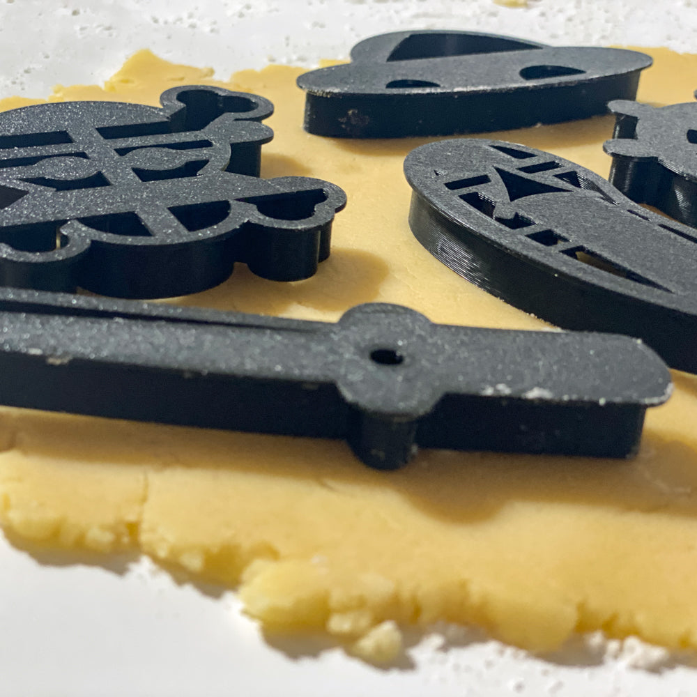 Emporte-pièces pirates des mers pour biscuits One Piece avec formes chapeau, gouvernail, tête de mort, sabre et sandale sur pâte sablée.