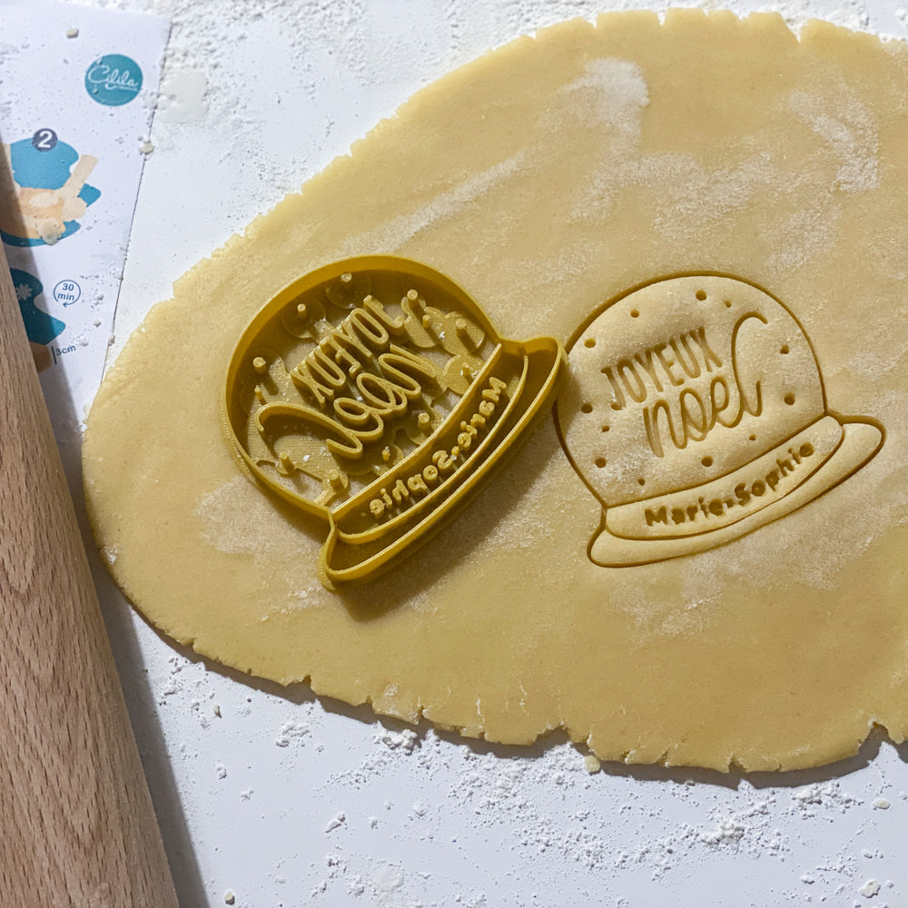 emporte-pieces boule a neige personnalise joyeux noel avec prenom grave dans une pate a biscuits maison